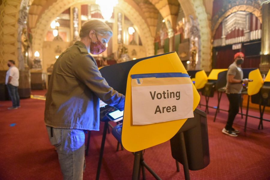 Poll workers wipe down each station after every use at the Pantages Theatre voting center in Los Angeles for the 2020 General Election.