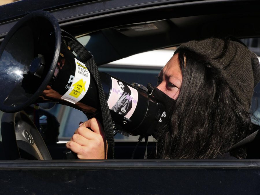 An activist speaks through a bullhorn during the car caravan protesting for the unhoused community on Monday, Jan. 18, 2020.