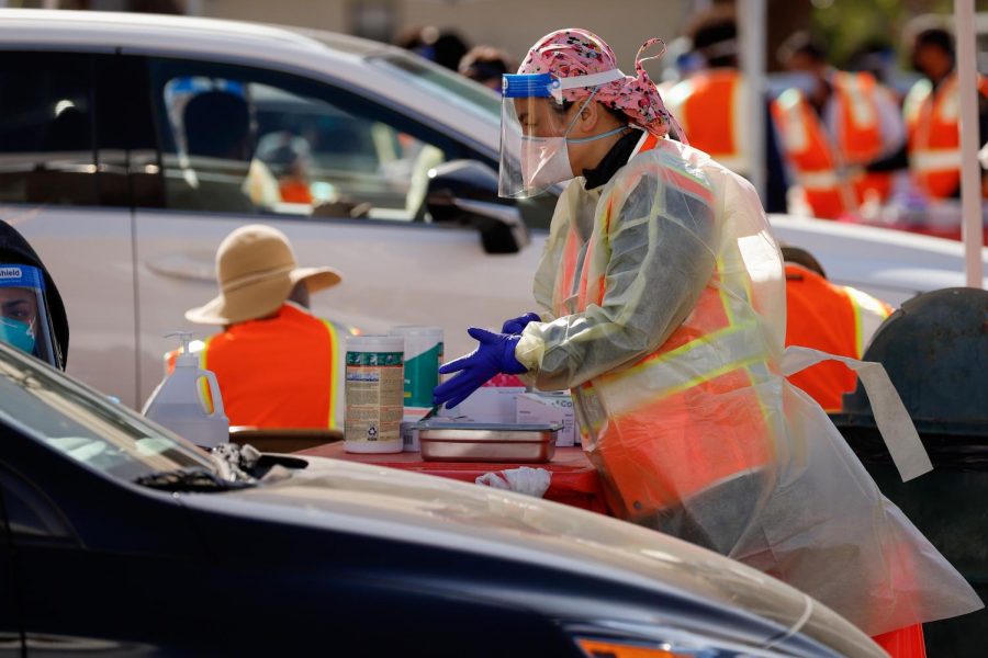 A worker at the CSUN COVID-19 vaccine distribution site prepares to administer a vaccination on  Tuesday, Jan. 19, 2021. Vaccinations are issued to the recipient while they are sitting in their car.