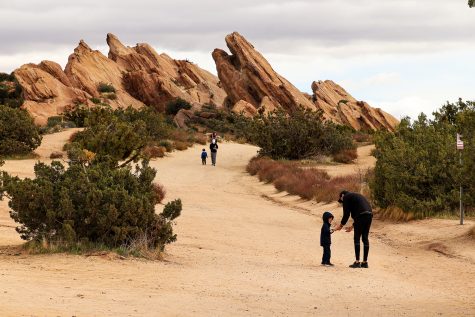 A father offers to carry his son the rest of the way while other families make their way back from climbing the beautiful natural structures in Vasquez Rocks Natural Area Park on Sunday, Feb. 14, 2021.