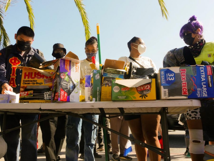 Clean-up participants pass out cleaning supplies in South Los Angeles on Saturday, Feb 27, 2021.