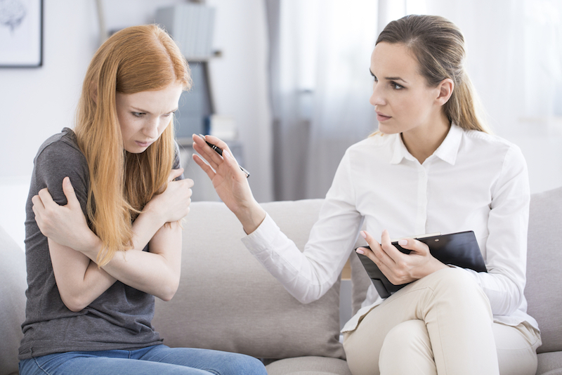 Psychotherapist reassuring teenager with problem
