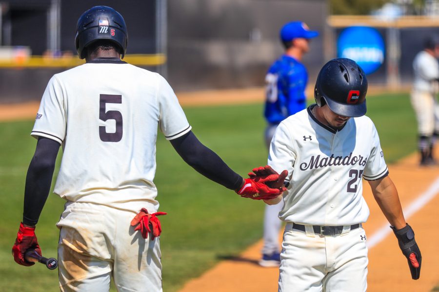 Denzel Clark, left, congratulates Mason Le, right, on his run during the second game of a double header against the UC Riverside Highlanders at Matador Field in Northridge, Calif., on Saturday, April 17, 2021. The Matadors lost both games 5-1 and 8-4.