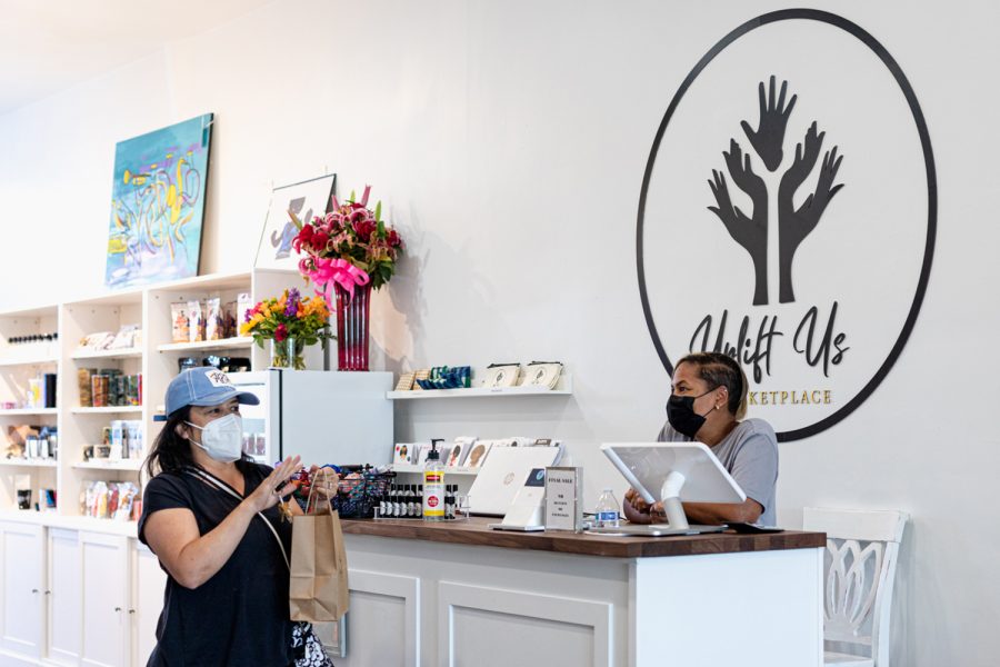 A customer chats with Kendra Settle at Uplift Us Marketplace in Granada Hills, Calif., on Saturday, Mar. 27, 2020.