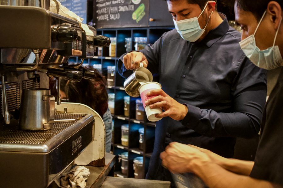 Barclay's Coffee & Tea owner Diego Lopez, left, prepares a drink for a customer at his cafe on Wednesday, April 21, 2021 in Northridge, Calif.