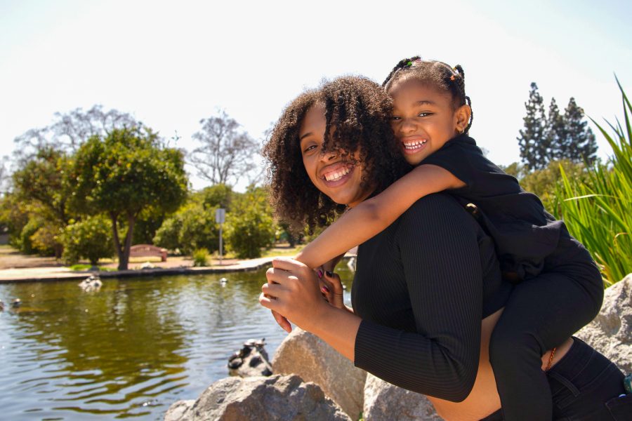 Ashanti Thomas, Quintens daughter, wraps her arms around the back of her mother, Saharra White, and pose for a portrait at the CSUN Duck Pond in Northridge, Calif.