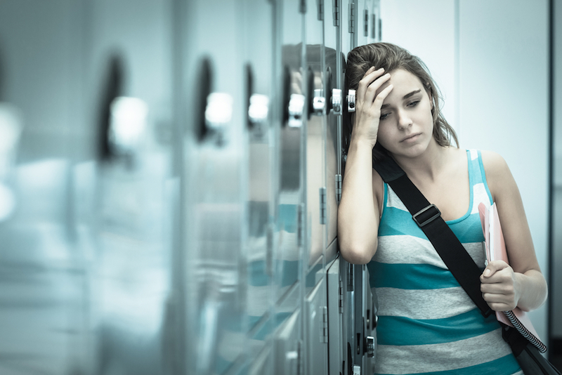 female student holding head at school
