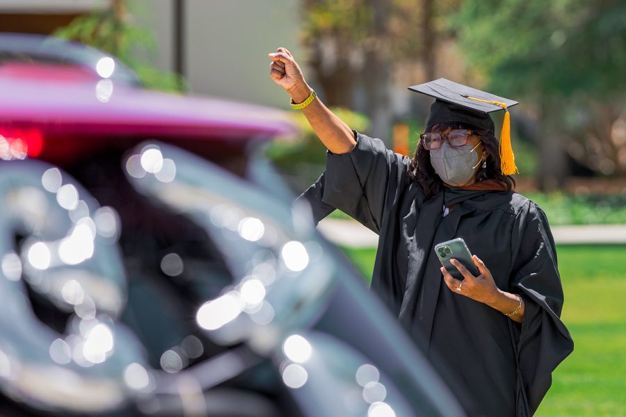 Dianah E. Wynter, a cinema and television professor, congratulates the 2020 and 2021 graduates as they drive past her during the CSUN Grad Parade at CSUN in Northridge, Calif., on Tuesday, May 25, 2021.