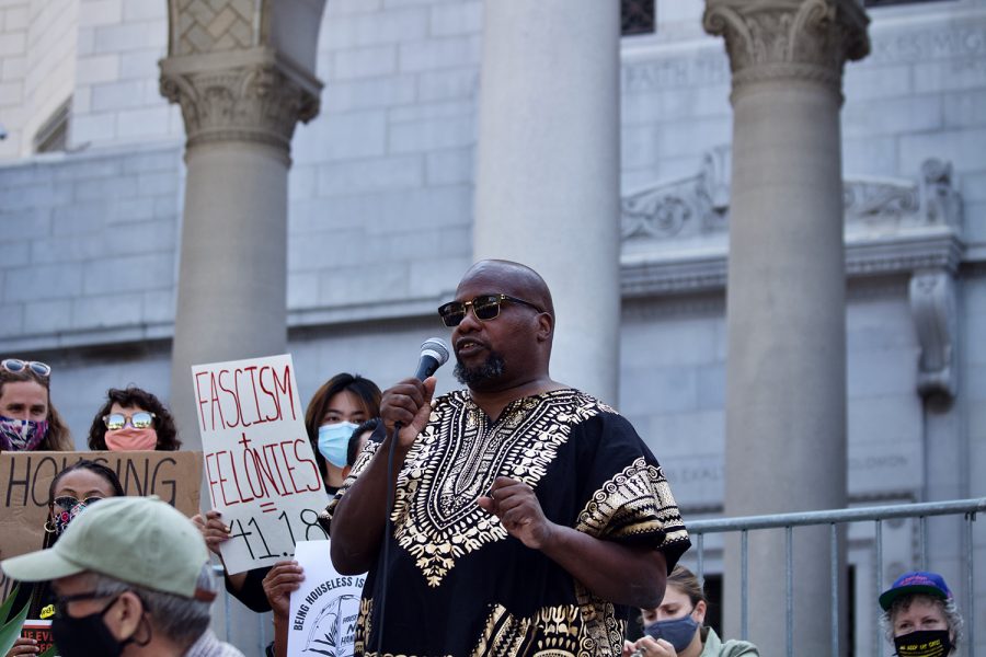 Theo Henderson, an unhoused community member, speaks at a rally in opposition of a proposed amendment to LA Municipal Code 41.18 on the steps of Los Angeles City Hall on Wednesday July 28, 2021 in Downtown Los Angeles, Calif. Theo hosts the podcast “We The Unhoused”, which invites members of the unhoused community to discuss their day to day struggles as they navigate housing insecurity.