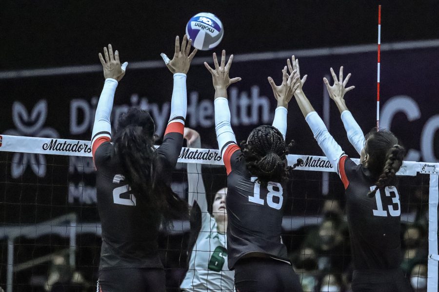 Seyvion Waggoner, left, Lauryn Anderson and Nicole Nevarez doing a triple block against Hawaii s outside hitter in Northridge, Calif., on Oct. 23, 2021.