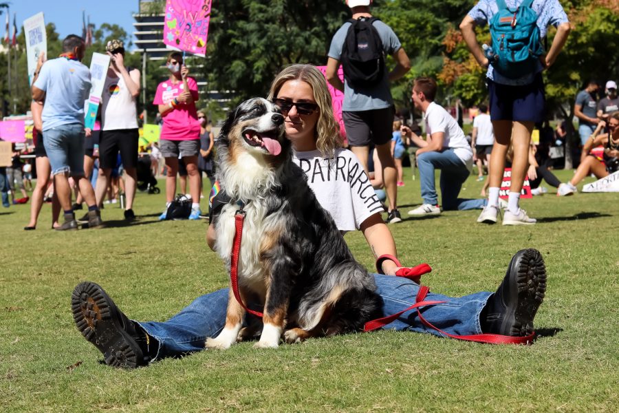 A participant and their dog sit on the grass at the march for women’s reproductive rights organized by Women’s March in downtown Los Angeles, Calif., Oct. 2, 2021.