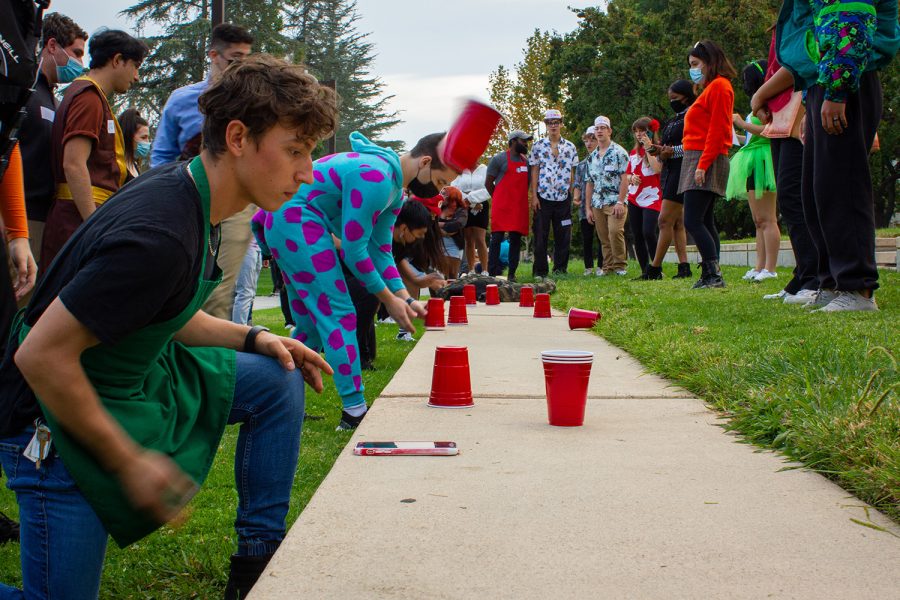 Teams of five line up and try to flip a red cup on the University Library Lawn in Northridge, Calif., on Sunday, Oct. 31, 2021.
