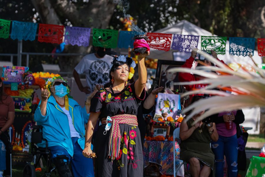 Beatriz Rosas raises a bowl of burning sage as the community joins in prayer during the closing ceremony of the Día de los Muertos Cultural Festival  in San Fernando, Calif., on Saturday, Oct. 30, 2021.
