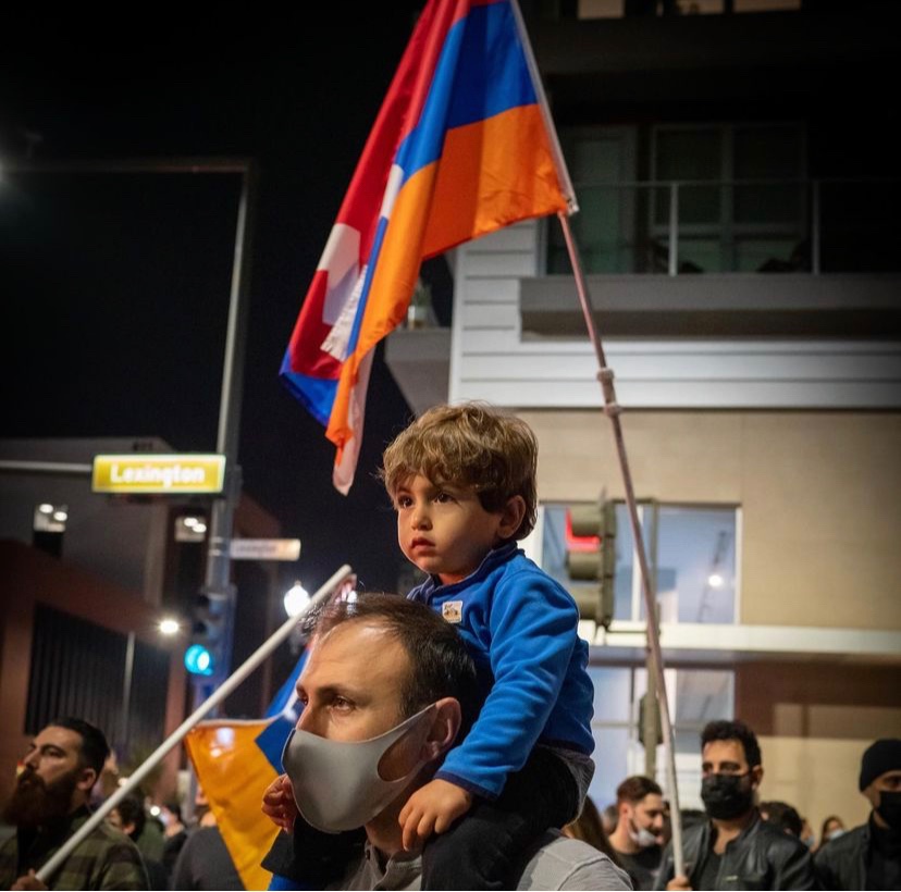 A young child sits upon his fathers shoulders during the anniversary of the Nagorno-Karabakh ceasefire agreement on Nov. 10, 2021.