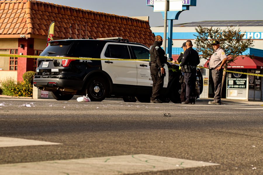 Napkins and remains from a to-go bag strewn across the intersection of Reseda Boulevard and Prairie Street in Northridge, Calif., on Dec. 3, 2021. Officers figure out a way to remove the car from the curb.
