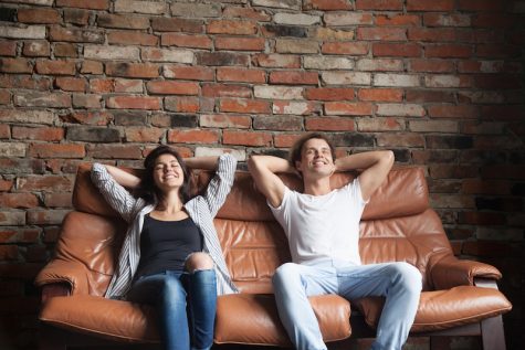 man and woman relaxing on big couch