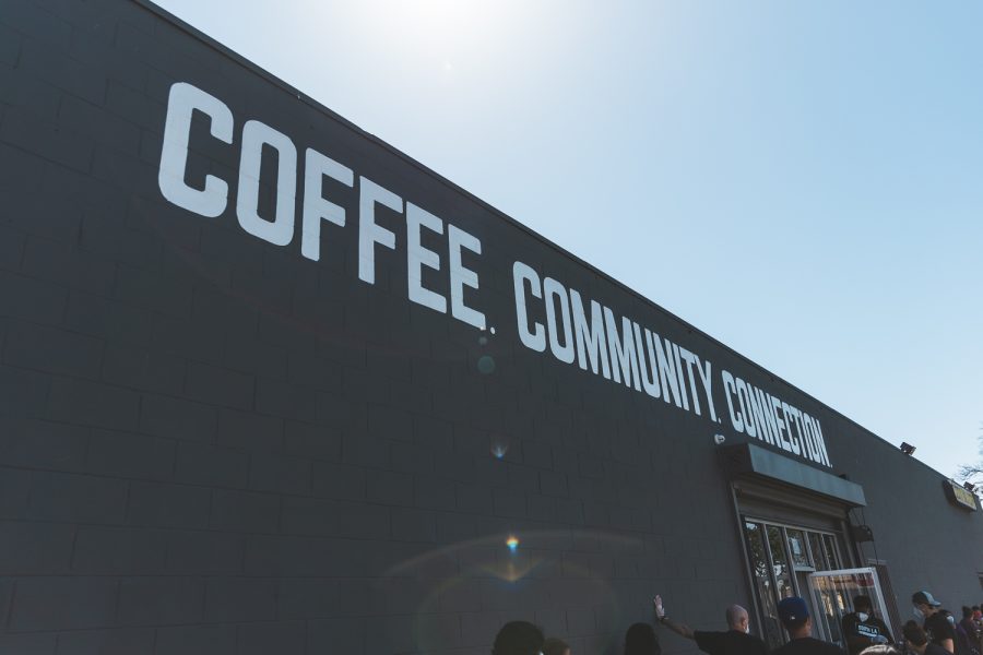 COFFEE. COMMUNITY. CONNECTION. is painted in white on the outer wall of South L.A. Cafe in South Los Angeles, Calif., on March 31, 2021.