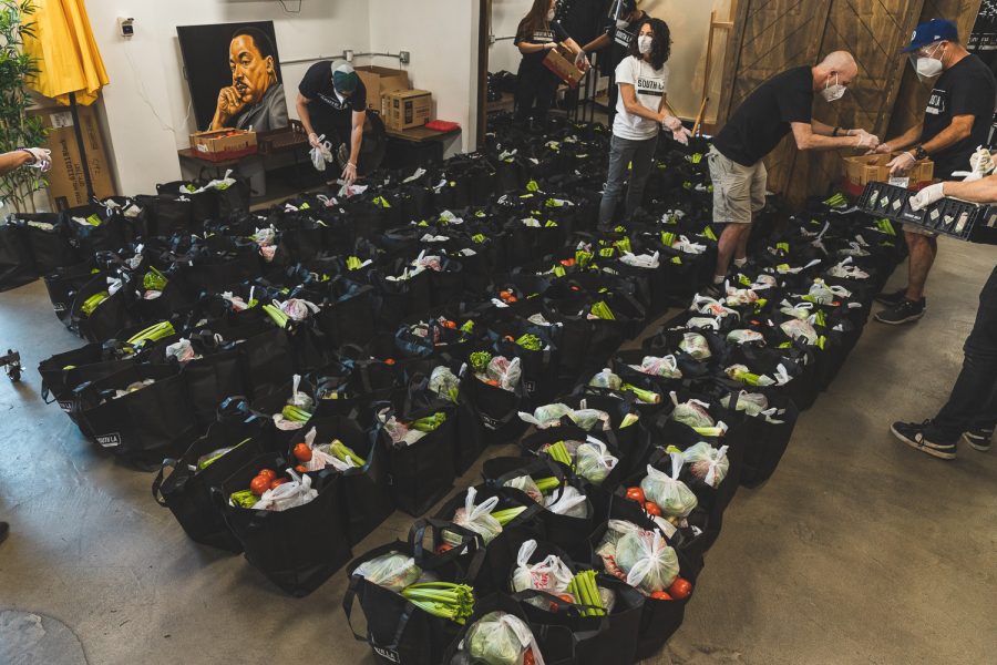 Volunteers put fresh produce into individual grocery bags that will be handed out to the community of South L.A. during South LA Cafe's weekly food drive in South Los Angeles, Calif., on March 31, 2021.