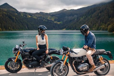 woman and man on motorcycles by a lake