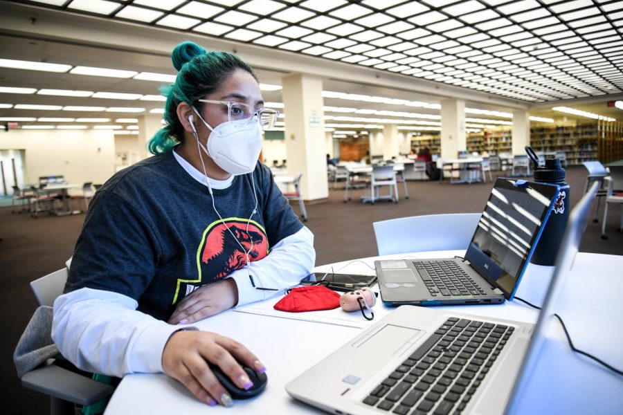 Ashley Guillen multitasks with two labtops in the CSUN University Library on Jan. 27, 2022, in Northridge, Calif.