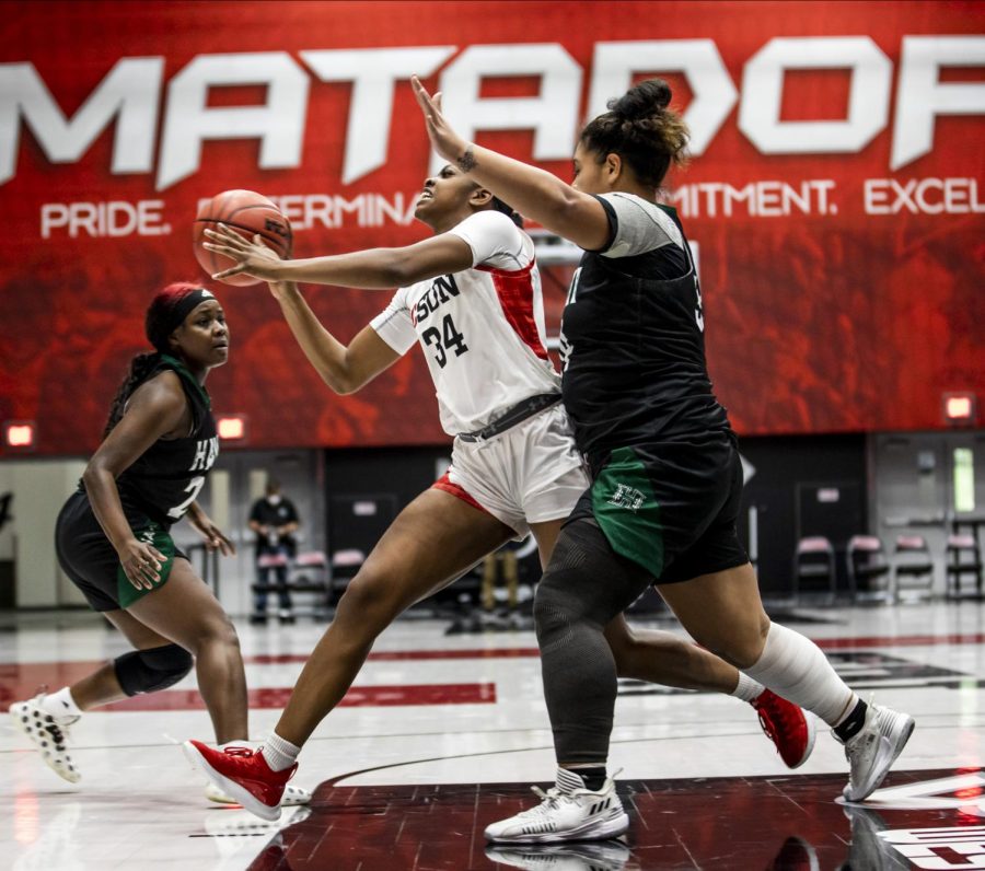 NORTHRIDGE CALIF. JAN 29, 2022 - (L-R) - Kayanna Spriggs (34) drives against a member of the University of Hawaii women’s basketball team at The Matadome during a home game in Northridge, Calif., on Jan. 29, 2022. The Matadors lost 67-76 to the University of Hawaii.