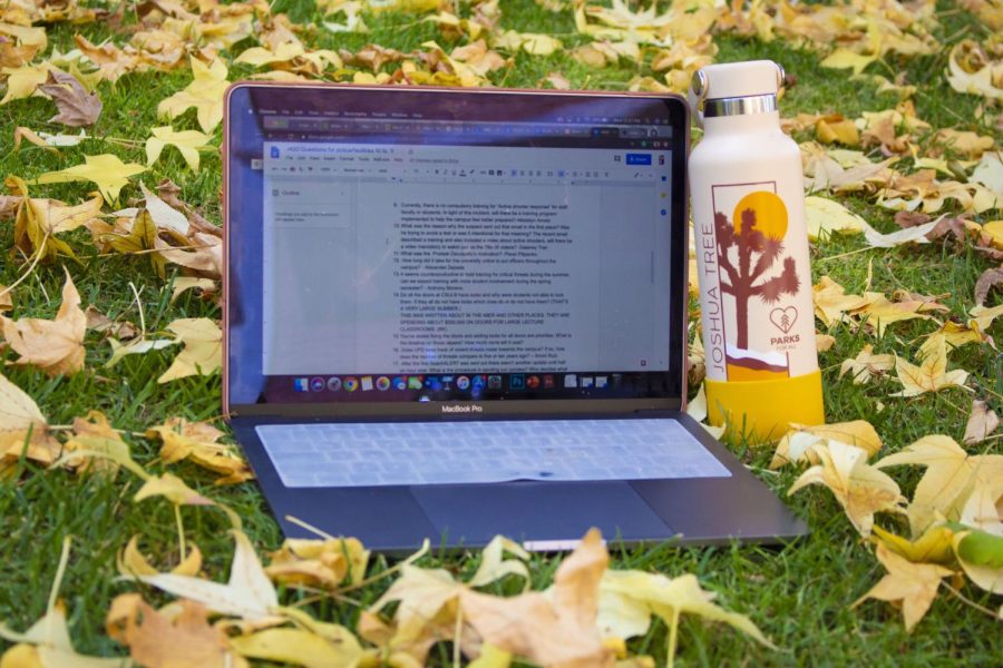 A picture of a computer and a bottle in the grass
