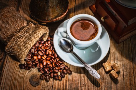 coffee, beans, and grinder on a wooden table