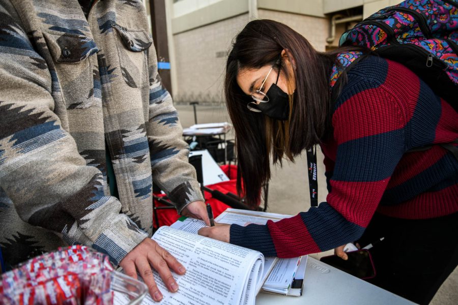 Maria Salazar signs a petition at CSUN on Feb. 24, 2022, in Northridge, Calif.