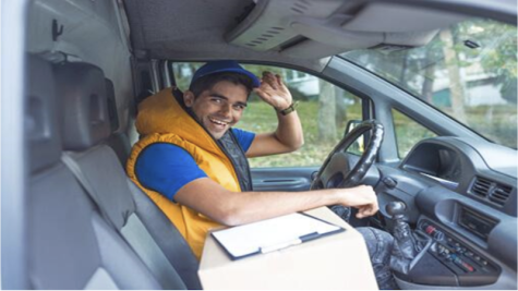 Delivery driver inside a vehicle witha clipboard and package