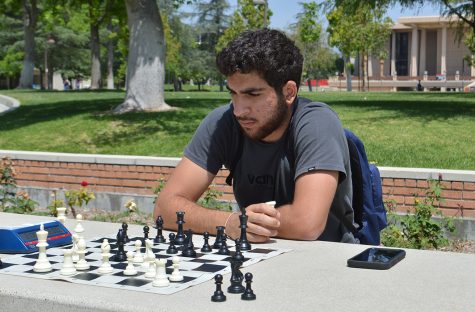 Haig Amloyan plays chess outside of Manzanita Hall on May 2, 2022, in Northridge, Calif.