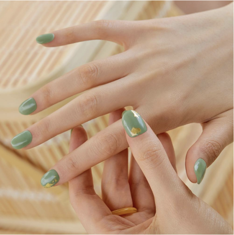 hands with green and gold fingernail polish