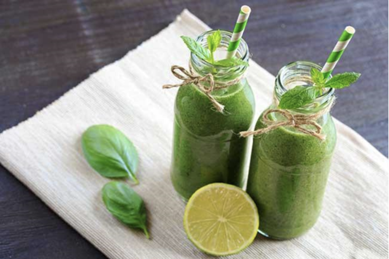 two+bottles+of+green+drinks+with+lime+and+basil+leaves+on+a+napkin