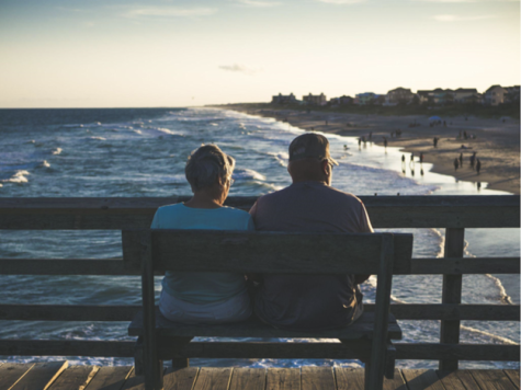 couple sitting on a bench on a pier