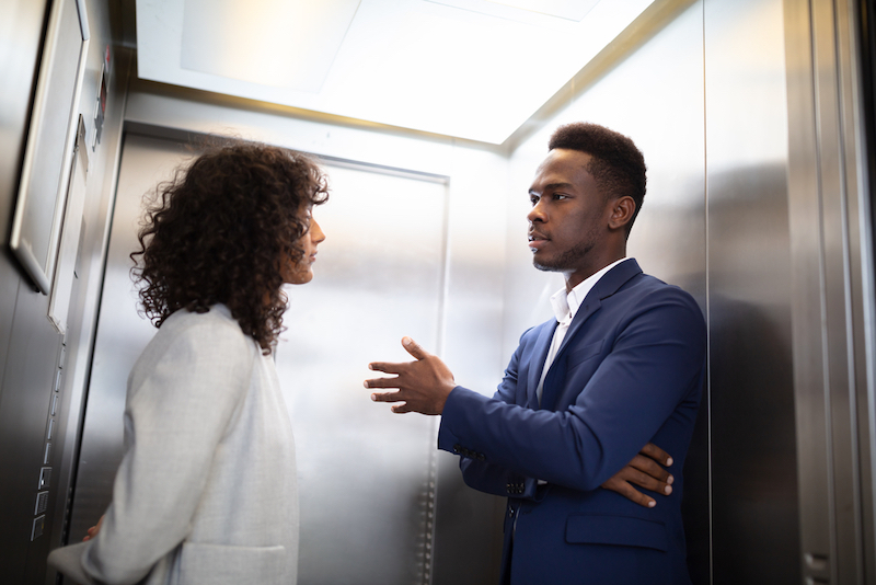 Businesspeople Having Conversation In Elevator