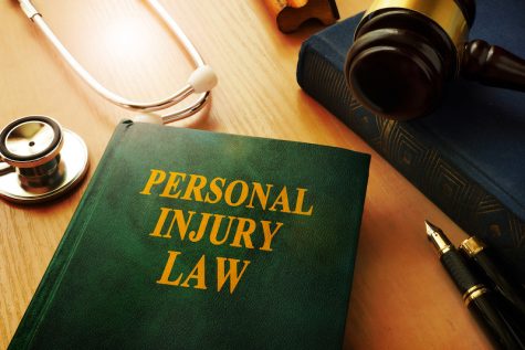 book on personal injury law on top of a table with stethoscope and gavel