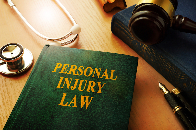 book on personal injury law on top of a table with stethoscope and gavel