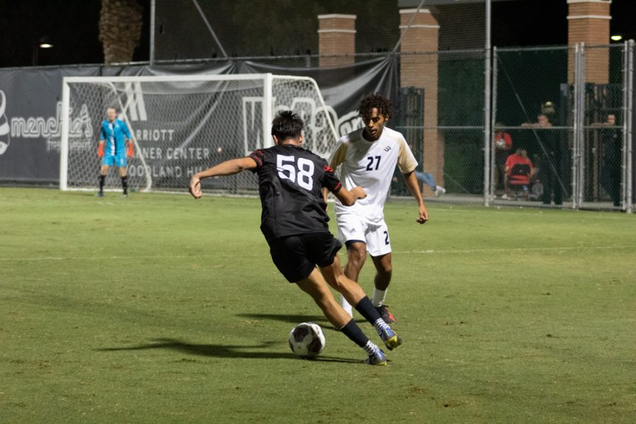 CSUN forward David Diaz, 58, dribbles the ball against UC Davis defender Cole Pond, 27, on Saturday, Oct. 8, 2022, at the Performance Soccer Field in Northridge, Calif.