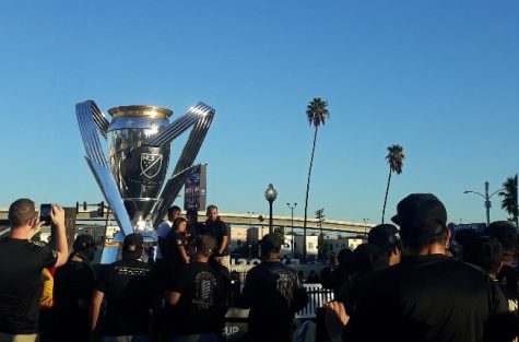 LAFC fans line up in front of the giant replica of the Philip F. Anschutz Trophy, waiting to take a photo with the cup their team just brought home as champions on Sunday, Nov. 6, 2022, at 4 p.m. outside the Banc of California Stadium in Los Angeles, Calif.