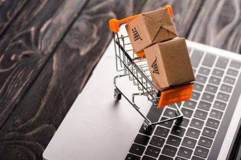 tiny shopping cart and shipping boxes on top of a laptop