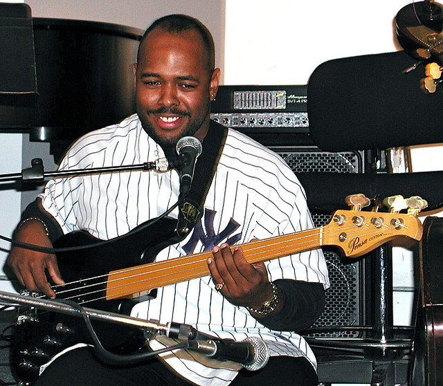 A man playing his guitar and with a microphone