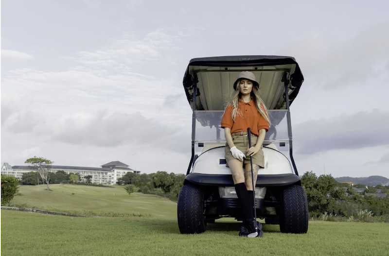 A girl in front of a mini golf cart
