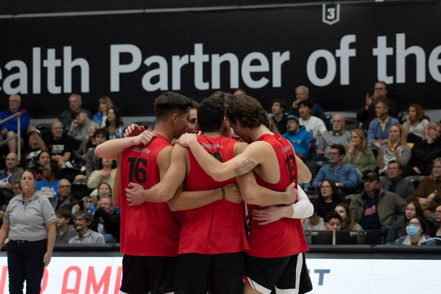 CSUN mens volleyball team hugging each other