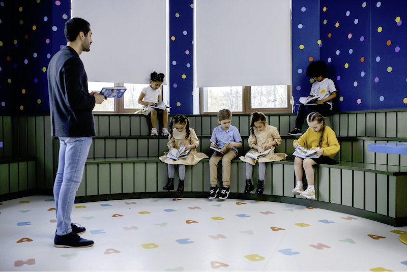 Man teaching 6 children in a large room