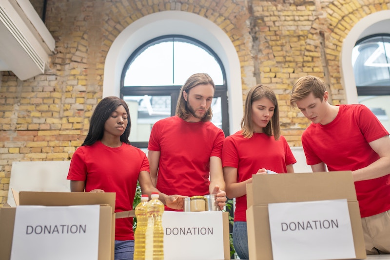 group of men and women in red tshirts packing donation boxes