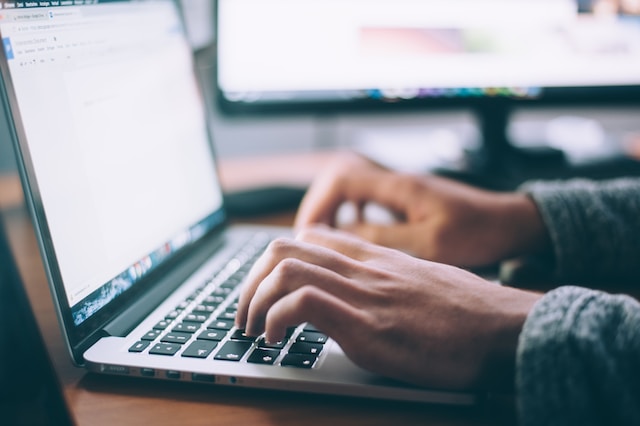 closeup of hands typing on a laptop