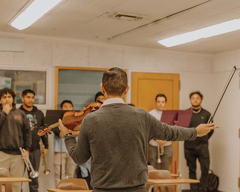 Professor Carlos Samaniego instructs his students during mariachi practice.