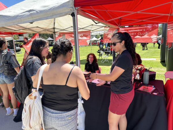 A CSUN women’s rugby club member talks about the team to “Welcome Party” visitors.