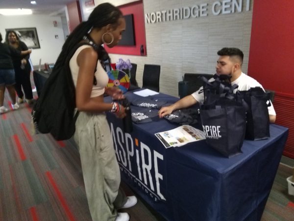 File photo. A student checks out the Aspire apartments showcase table at the Welcome Black event in the Northridge Center of the USU on Sept. 13, 2023.