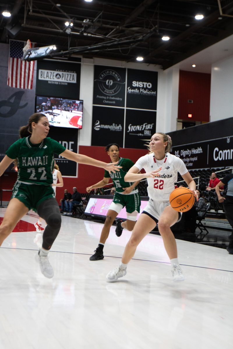 Kaitlyn Elsholz, 22, guard for CSUN Women’s basketball team, dribbling between two Hawaii Rainbow Wahine players during their match at the Premier America Credit Union Arena on Thursday, March 7, 2024, in Northridge, Calif.