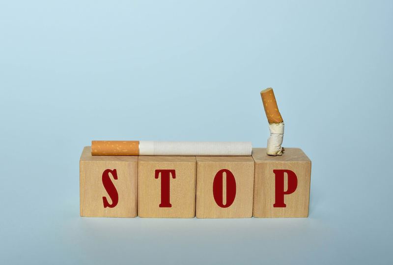 Stop smoking concept, cigarettes and STOP text on wooden blocks. World No Tobacco Day on May 31 concept. Selective focus
